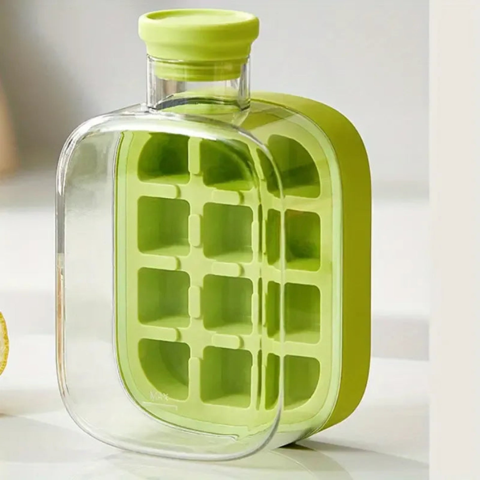 Green ice cube tray with clear container on a white surface